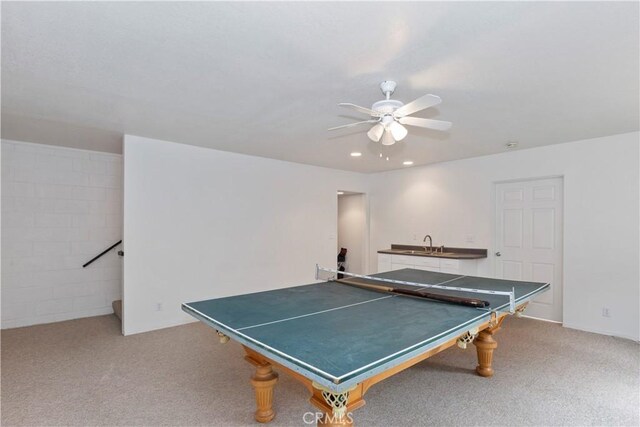 rec room with ceiling fan, sink, and light colored carpet