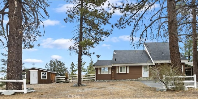 rear view of house featuring a shed