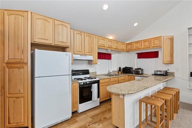 kitchen with light brown cabinets, a kitchen breakfast bar, kitchen peninsula, vaulted ceiling, and white appliances