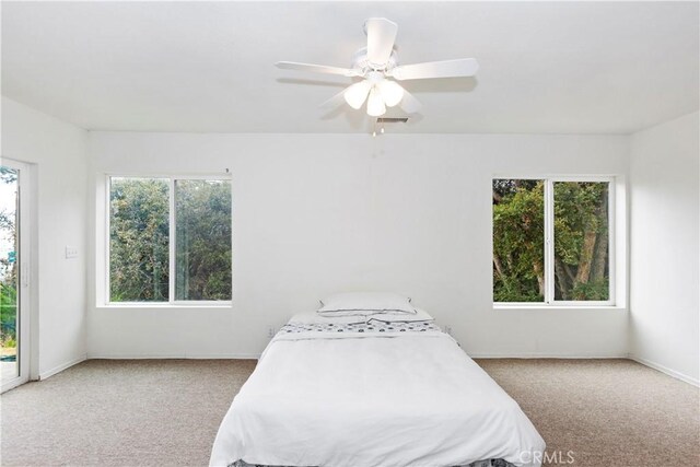 bedroom with carpet flooring, multiple windows, and ceiling fan