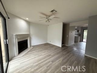 unfurnished living room with hardwood / wood-style flooring and ceiling fan