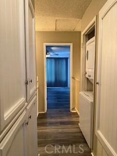 corridor featuring dark hardwood / wood-style flooring and stacked washer and clothes dryer