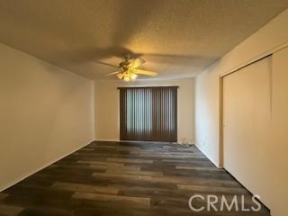 spare room featuring ceiling fan and dark wood-type flooring