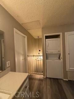 interior space with stacked washer / dryer, dark hardwood / wood-style flooring, and a textured ceiling