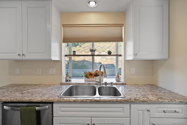 kitchen featuring dishwasher, sink, and white cabinets