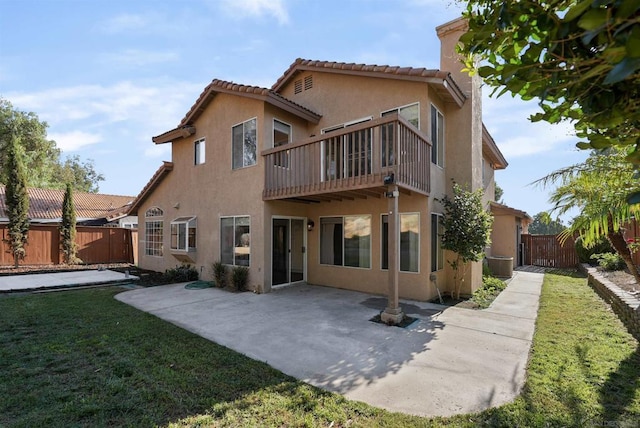 back of property with a patio area, a yard, and a balcony