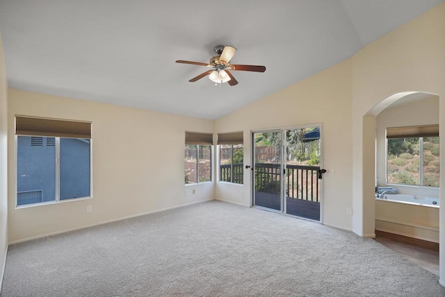 spare room featuring carpet flooring, ceiling fan, a healthy amount of sunlight, and vaulted ceiling