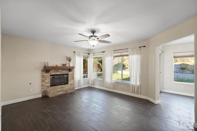 unfurnished living room with dark wood-type flooring, ceiling fan, and a healthy amount of sunlight