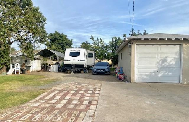 view of side of property with an outbuilding, a yard, a garage, and a carport