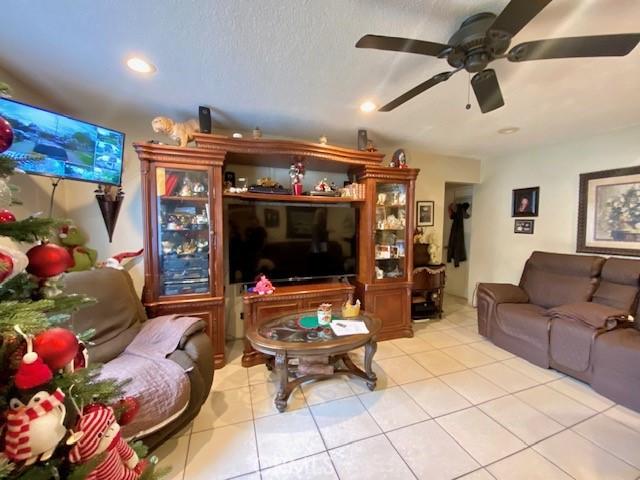 tiled living room with ceiling fan