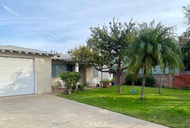 ranch-style home featuring a garage and a front lawn