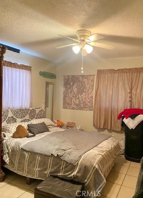 tiled bedroom featuring ceiling fan and a textured ceiling