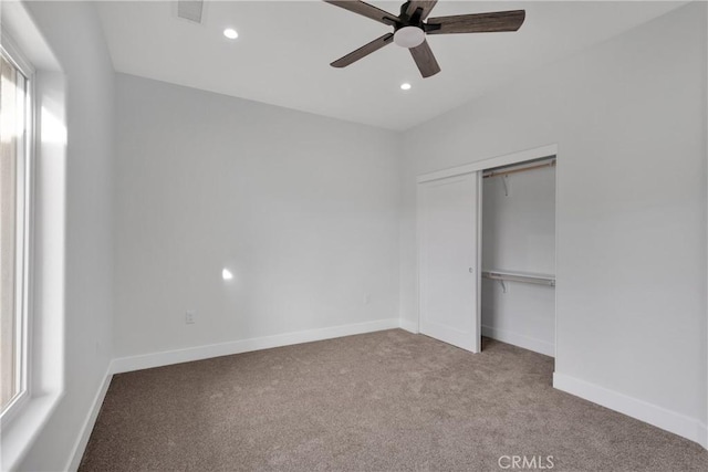 unfurnished bedroom featuring a closet, ceiling fan, and light colored carpet