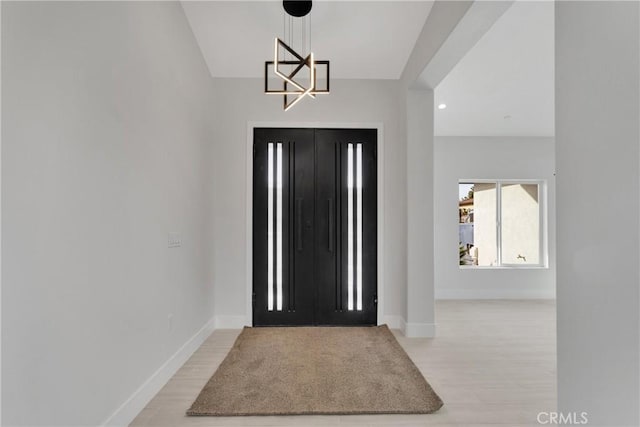 entrance foyer with light hardwood / wood-style flooring and a notable chandelier