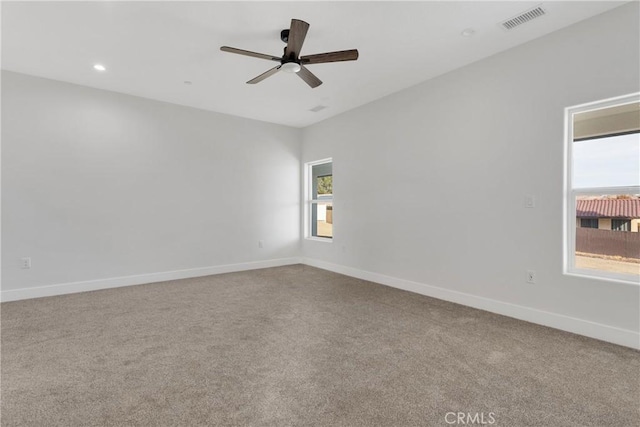 unfurnished room with ceiling fan, plenty of natural light, and carpet