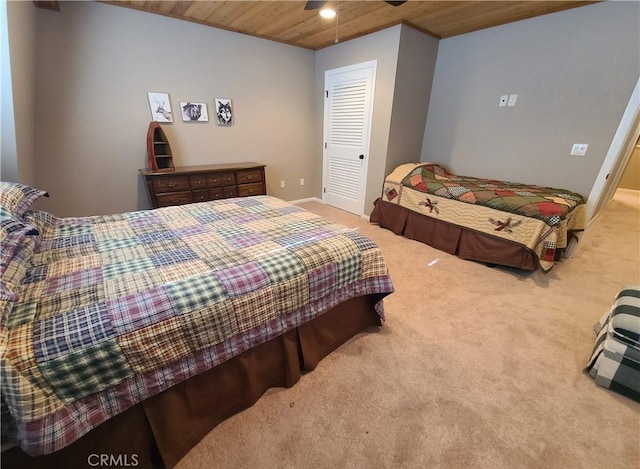 carpeted bedroom with wood ceiling and ceiling fan