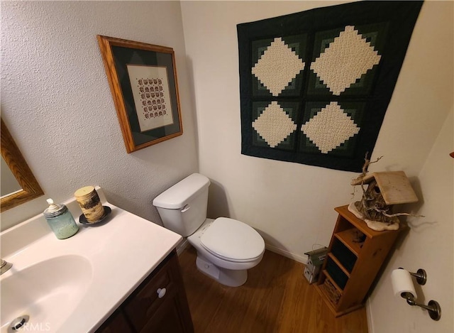 bathroom with vanity, hardwood / wood-style floors, and toilet