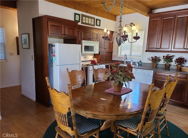 dining room with sink, wood ceiling, beam ceiling, a notable chandelier, and light hardwood / wood-style floors