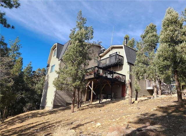 rear view of house featuring a wooden deck