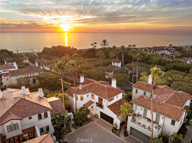 aerial view at dusk featuring a water view