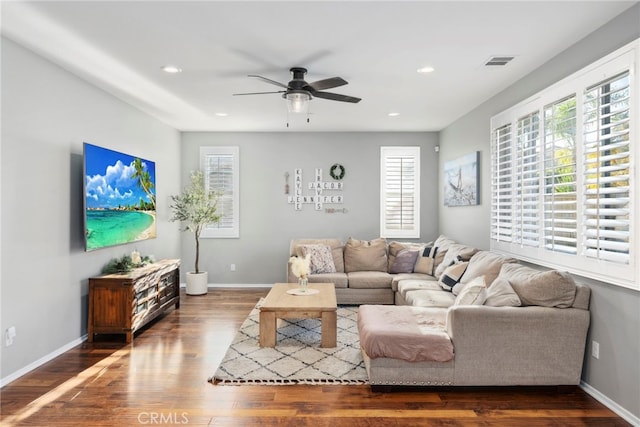 living room with ceiling fan and dark hardwood / wood-style flooring