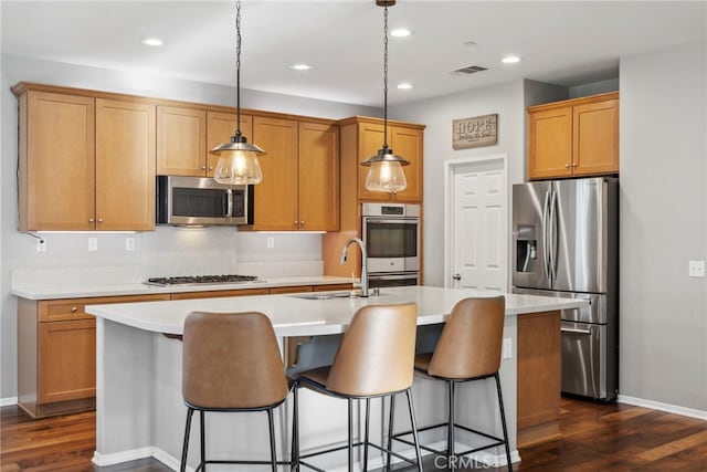 kitchen featuring sink, a center island with sink, pendant lighting, and appliances with stainless steel finishes