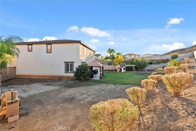 back of property with a gazebo and a lawn