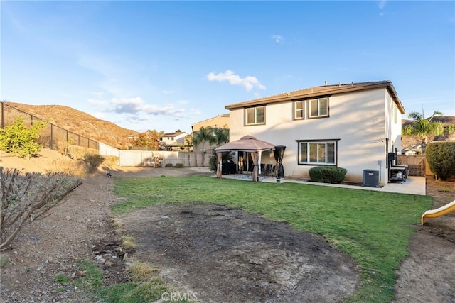 back of property featuring a mountain view, a lawn, a patio area, and a gazebo