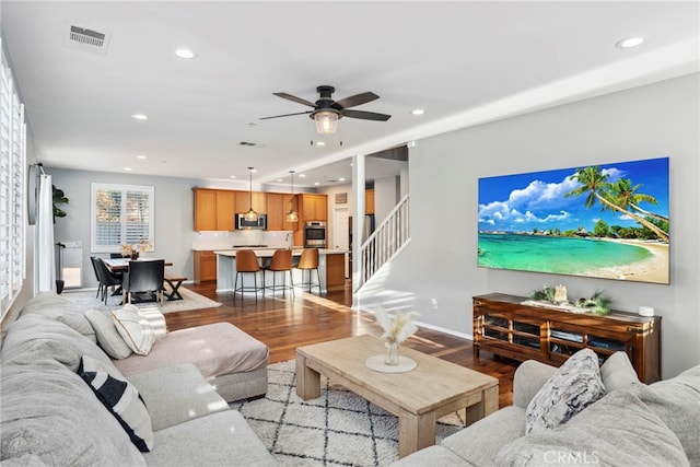 living room featuring light wood-type flooring and ceiling fan