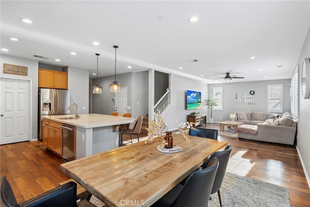 dining space with sink, dark wood-type flooring, and ceiling fan