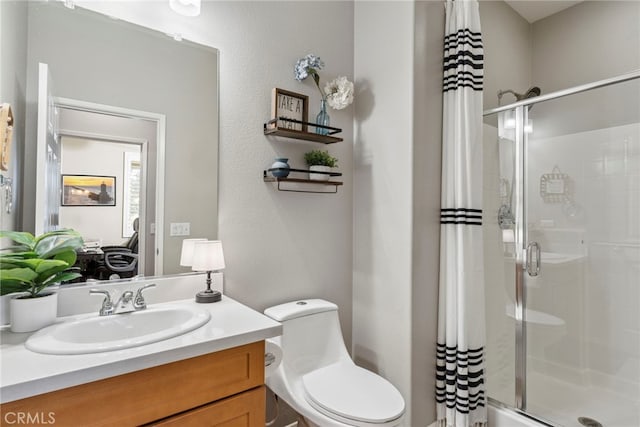 bathroom with vanity, a shower, and toilet