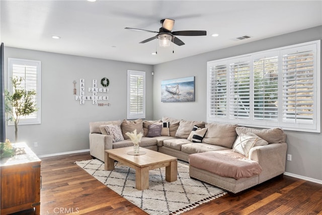 living room featuring a healthy amount of sunlight, ceiling fan, and dark hardwood / wood-style floors