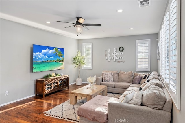 living room featuring ceiling fan and dark wood-type flooring