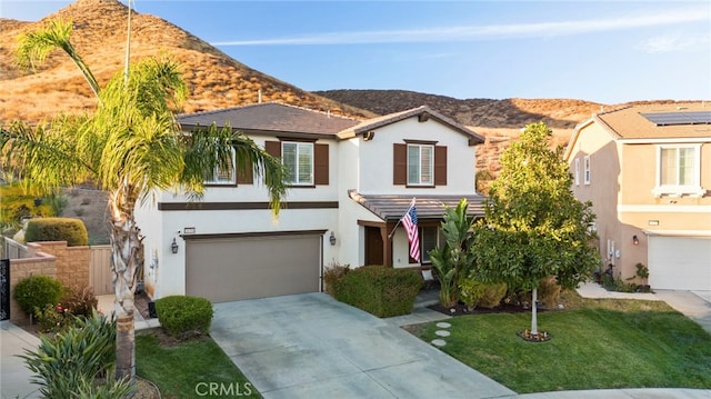 view of front of home featuring a front yard, a garage, and a mountain view