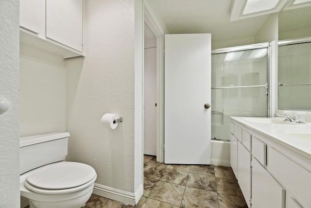 full bathroom featuring vanity, toilet, and shower / bath combination with glass door