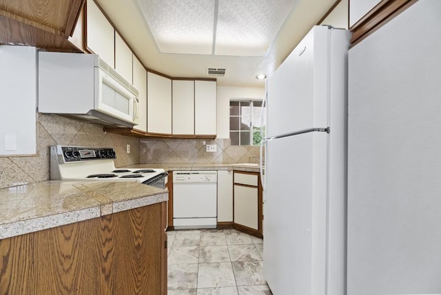 kitchen with white cabinetry, white appliances, and backsplash