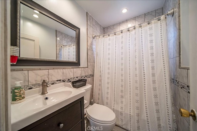 bathroom with a shower with curtain, toilet, decorative backsplash, vanity, and tile walls