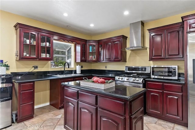 kitchen featuring appliances with stainless steel finishes, sink, and wall chimney range hood