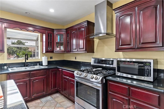 kitchen featuring light tile patterned flooring, appliances with stainless steel finishes, sink, and wall chimney range hood