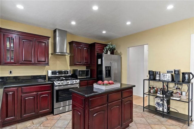 kitchen with a kitchen island, wall chimney exhaust hood, and appliances with stainless steel finishes