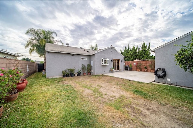 back of property featuring a lawn and a patio