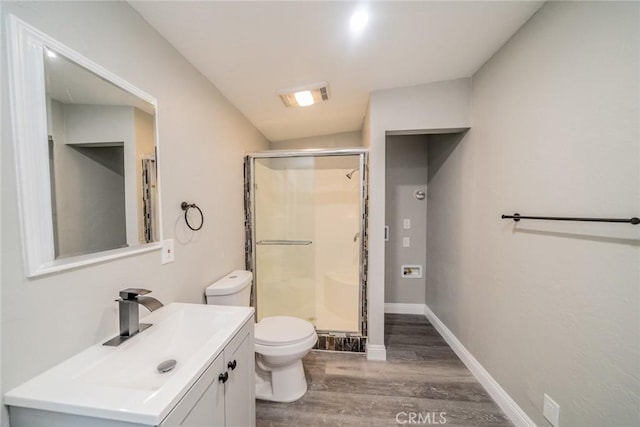 bathroom featuring hardwood / wood-style floors, lofted ceiling, an enclosed shower, toilet, and vanity