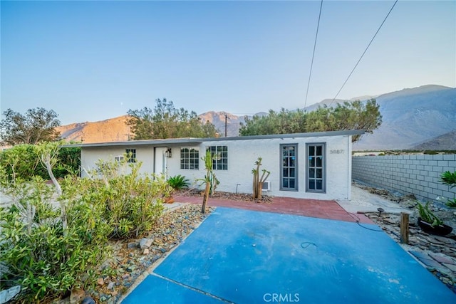 back of property featuring a mountain view, french doors, and a patio