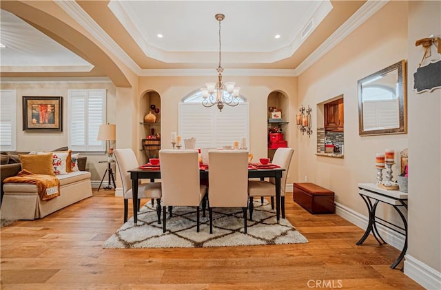 dining room with a healthy amount of sunlight, light wood-type flooring, and ornamental molding