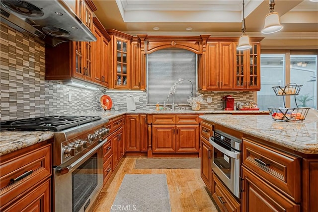 kitchen with light stone countertops, extractor fan, crown molding, and appliances with stainless steel finishes