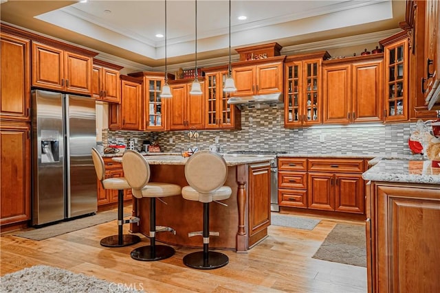 kitchen featuring a kitchen island, light wood-type flooring, light stone countertops, and appliances with stainless steel finishes