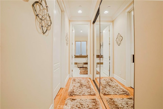 corridor featuring ornamental molding and light hardwood / wood-style flooring