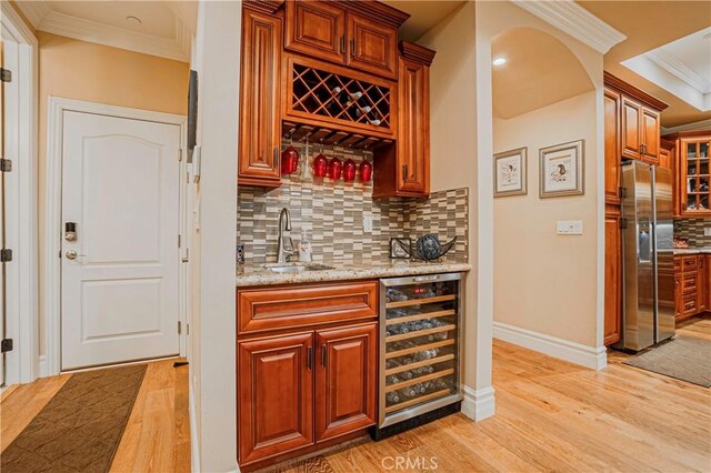 bar with sink, stainless steel refrigerator with ice dispenser, wine cooler, light hardwood / wood-style flooring, and decorative backsplash