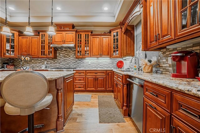 kitchen with backsplash, light stone counters, stainless steel appliances, sink, and decorative light fixtures