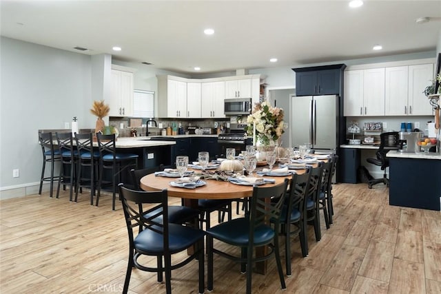 dining area featuring sink and light hardwood / wood-style flooring